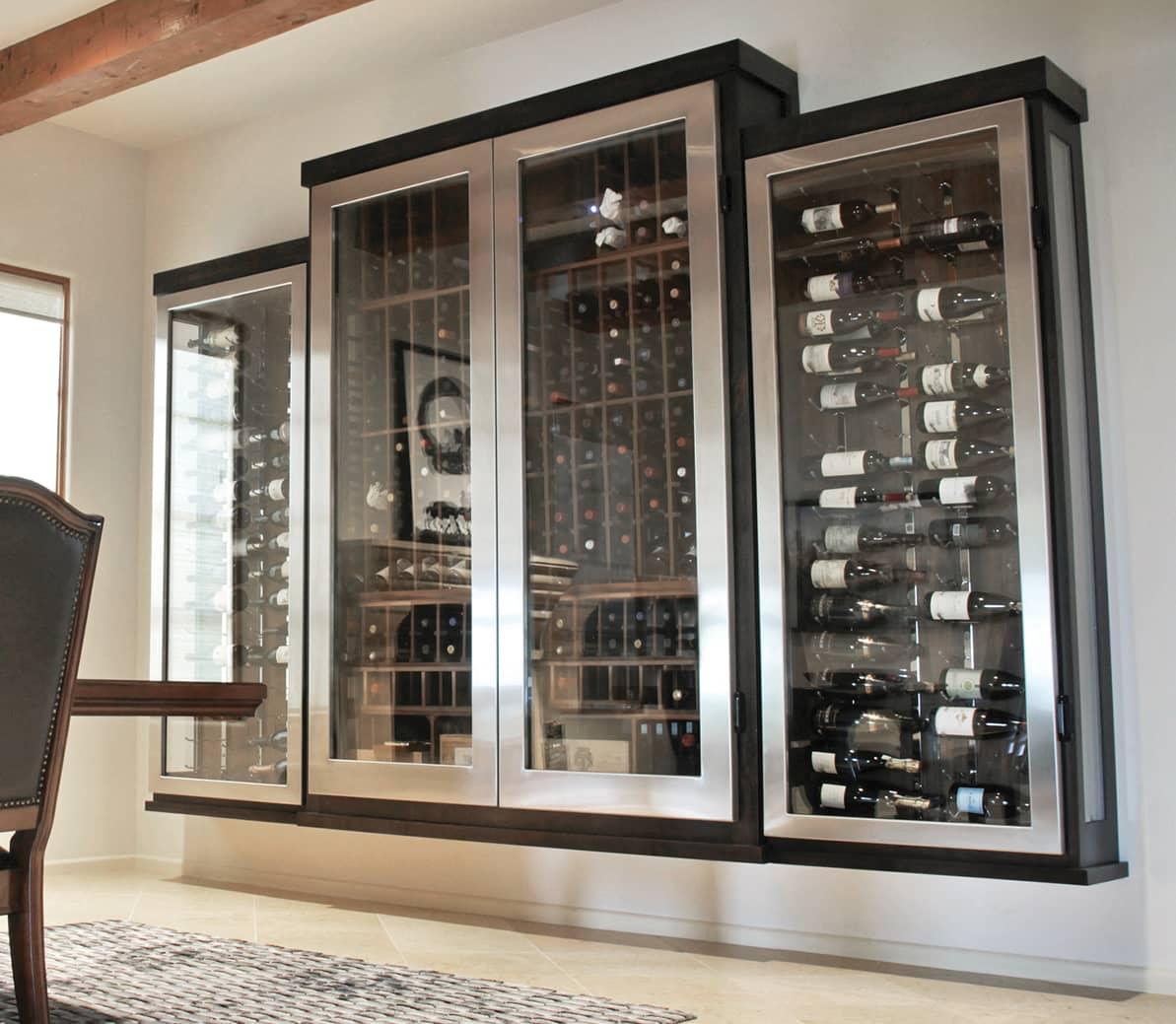 Dramatic stainless steel edged custom glass enclosed wine cabinet.