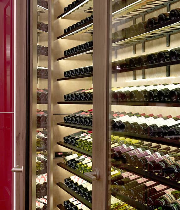 Rows of wine bottles behind glass doors.