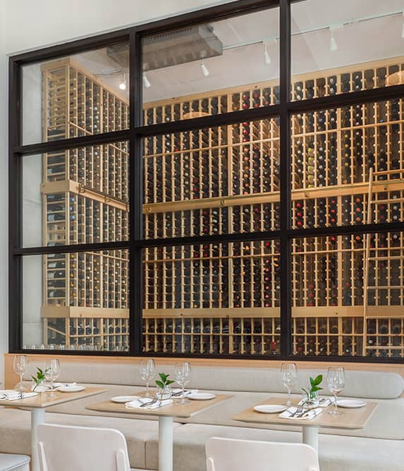 Glass enclosed cellar with wood wine racks.