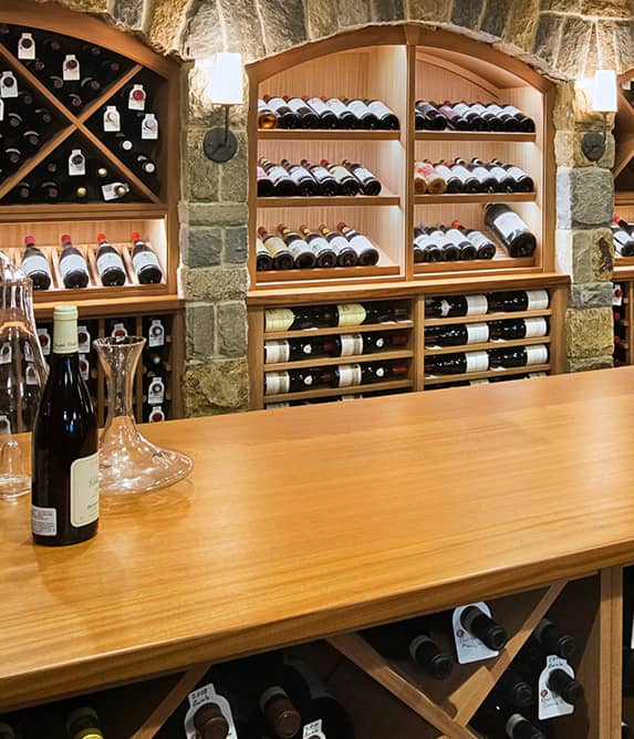 Wine tasting table with wood wine racks in the background.