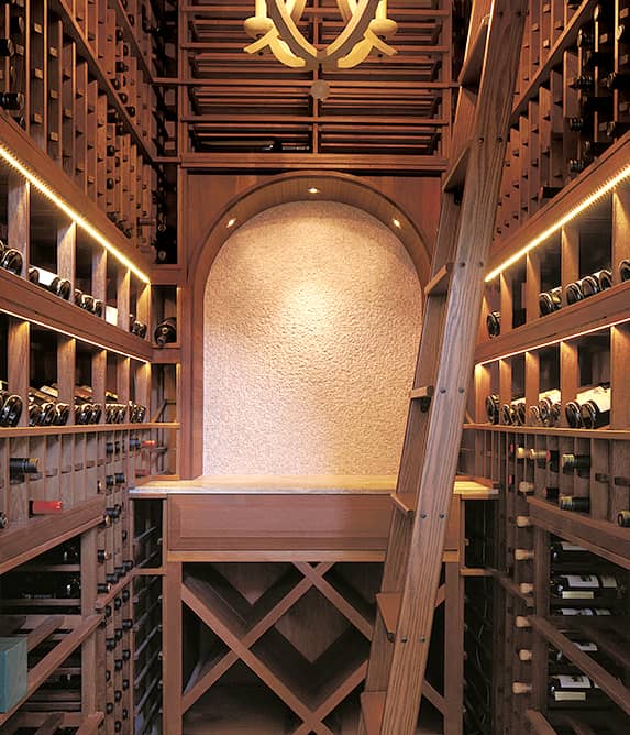 Wood wine room with ladder and decorative arch.